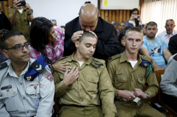 Elor Azaria’s father kisses his son's head in a military court during a remand hearing for his case