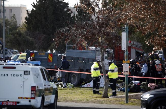 Israeli security forces gather around a flatbed truck at the site of a ramming attack in Jerusalem