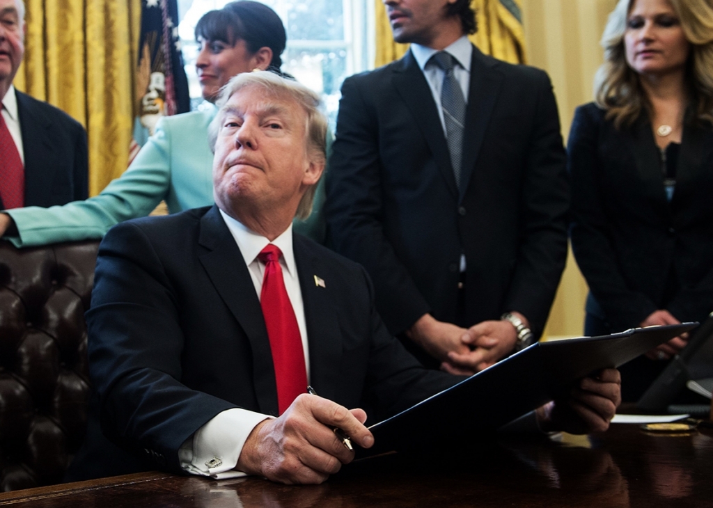 US President Donald Trump reacts after signing an executive order with small business leaders in the Oval Office at the White House in Washington DC