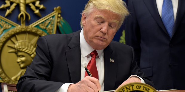 President Donald Trump signs an executive order on extreme vetting at the Pentagon