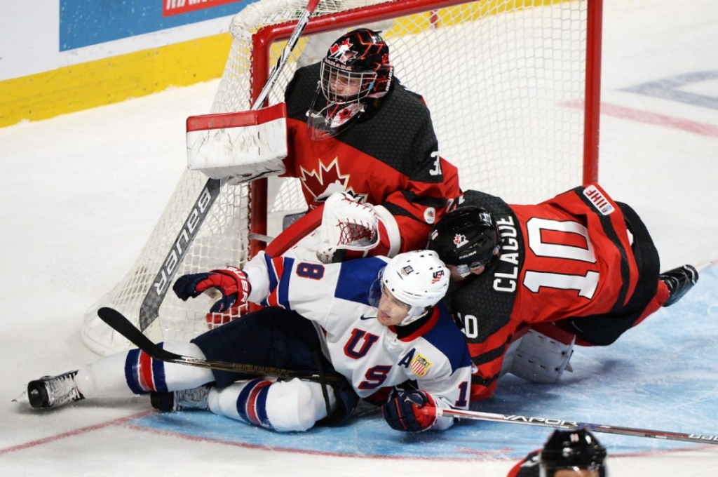 United States forward Colin White and Canada defenceman Kale Clague crash into Canada goaltender Carter Hart during first period gold medal game hockey action at the IIHF World Junior Championship Thursday