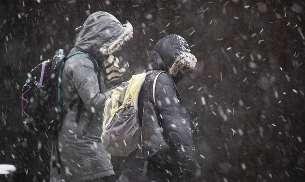 People walk bundled up against the cold and snow during a winter storm in Philadelphia Thursday Feb. 9 2017. A powerful fast-moving storm swept through the northeastern U.S. Thursday making for a slippery morning commute and leaving some residents