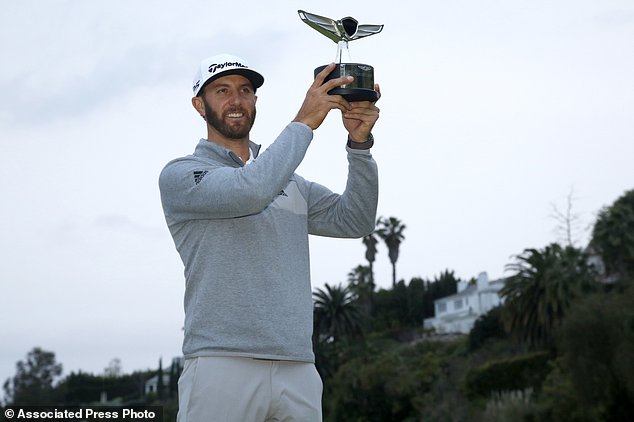 Dustin Johnson poses with his trophy on the 18th green after winning the Genesis Open golf tournament at Riviera Country Club on Sunday Feb. 19 2017 in the Pacific Palisades area of Los Angeles