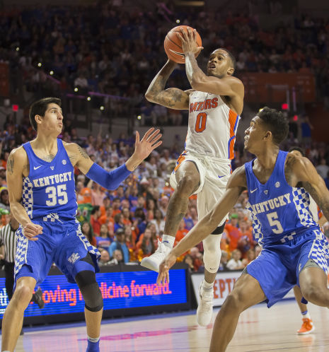 Florida guard Kasey Hill who scores a game-high 21 drives between Kentucky’s Derek Willis left and Malik Monk