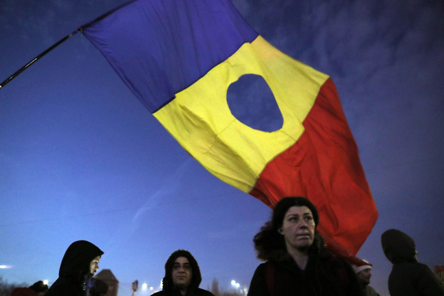 A girl waves a Romanian flag during a protest in Bucharest Romania Friday Feb. 3 2017. Romania's political crisis is deepening over a government decree