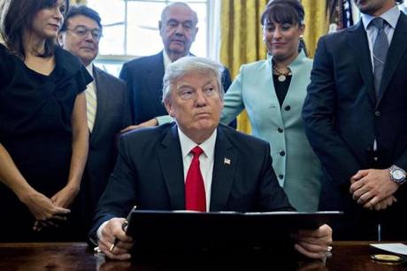 WASHINGTON DC- JANUARY 30  U.S. President Donald Trump pauses after signing an executive order in the Oval Office of the White House surrounded by small business leaders