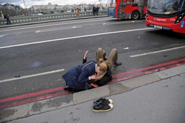 A woman assists an injured person after an incident on Westminster Bridge in London Britain