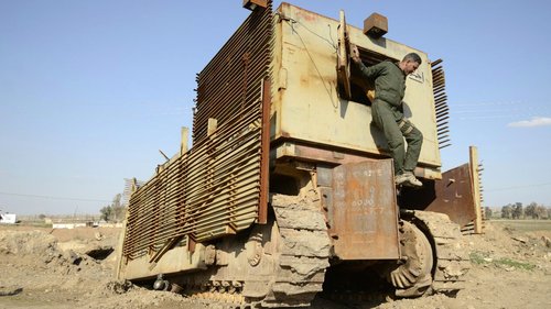 An Iraqi soldier inspects a captured Islamic State vehicle