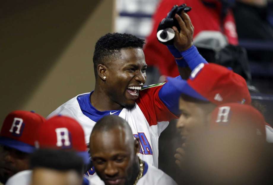 Dominican Republic's Gregory Polanco left celebrates with teammates in the dugout after he hit a solo home run against Venezuela during the fifth inning of a second-round World Baseball Classic game in San Diego Thursday