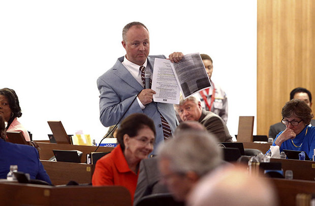 North Carolina House Minority Leader Darren Jackson holds a a copy of HB2 during debate on the state House floor on HB 142 on Thursday