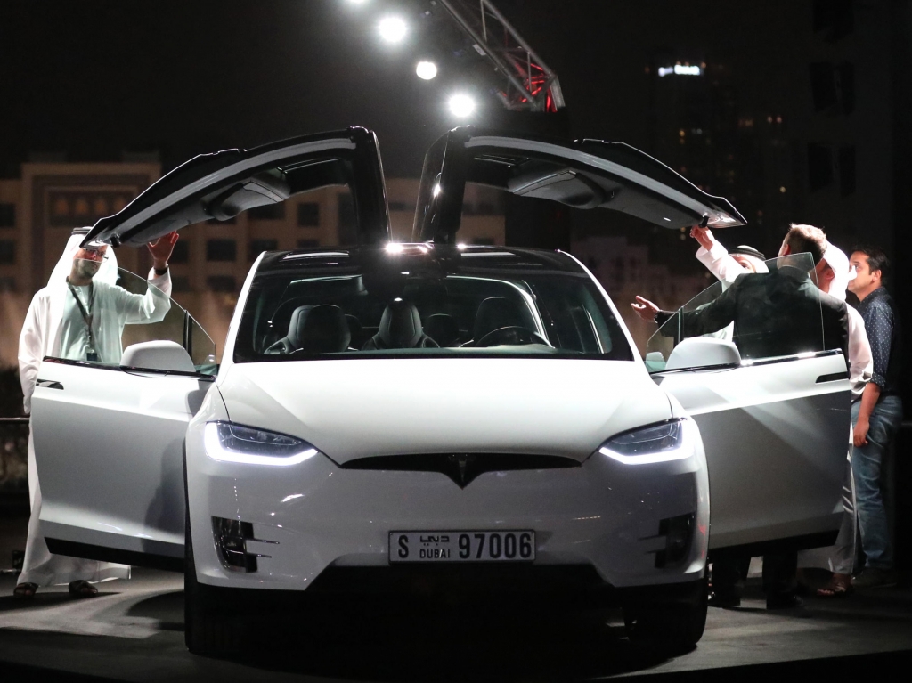 Emirati men check a Tesla vehicle during a ceremony in Dubai in February. The electric-vehicle maker recently announced the opening of a new Gulf headquarters in the United Arab Emirates