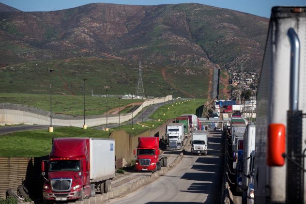 Trucks line up to cross to the United States near the Otay Commercial port of entry on the Mexican side of the U.S.-Mexico border on Jan. 25. Trump now says he will renegotiate the North American Free Trade Agreement which he has long criticized rather