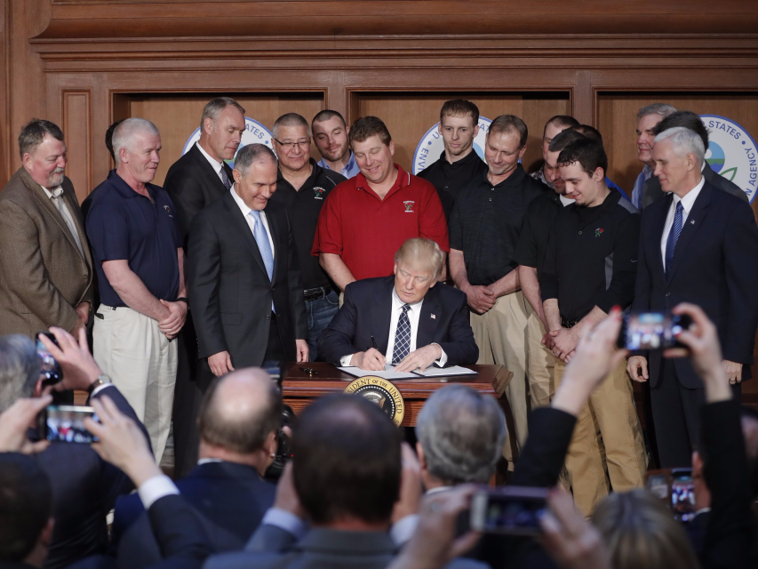 President Donald Trump accompanied by Environmental Protection Agency Administrator Scott Pruitt third from left and Vice President Mike Pence right signs an Energy Independence Executive Order Tuesday