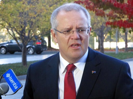 Australian Treasurer Scott Morrison talks to media as he arrives at Parliament House in Canberra Australia Tuesday