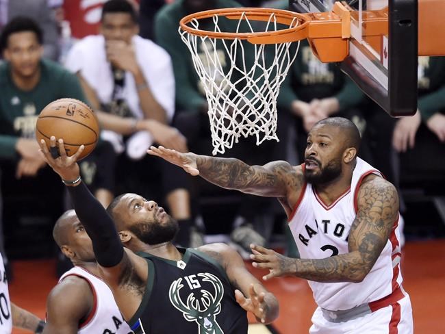 Milwaukee Bucks center Greg Monroe drives to the net for a basket over Toronto Raptors forward P.J. Tucker during the first half of game five of an NBA first-round playoff series basketball game in Toronto on Monday