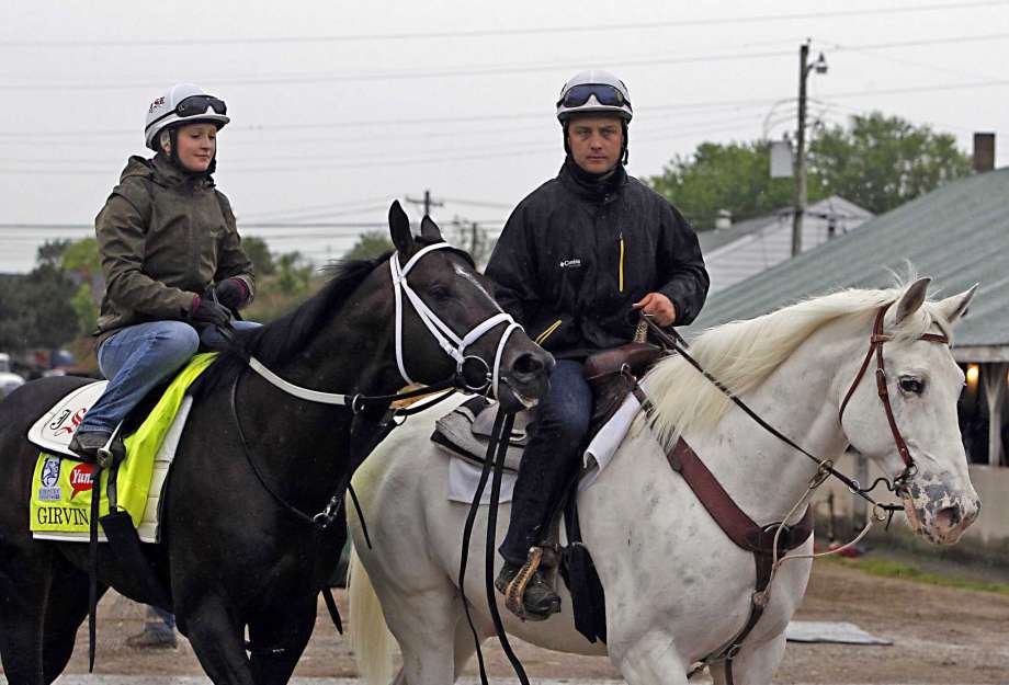 Trainer Joe Sharp right leads Kentucky Derby entrant Girvin ridden by wife Rosie Napravnik back to Barn 33 after a morning gallop at Churchill Downs