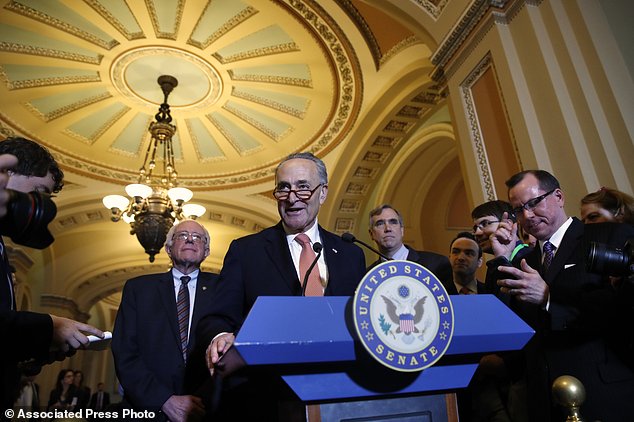 Senate Minority Leader Charles Schumer of N.Y. center flanked by Sen. Bernie Sanders I-Vt. left and Sen. Jeff Merkley D-Ore. meets with reporters on Capitol Hill in Washington Tuesday