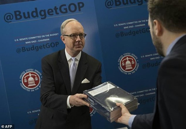 Eric Ueland Republican Staff Director of the Senate Budget Committee hands out copies of US President Donald Trump's Fiscal Year 2018 budget on Capitol Hill in Washington DC