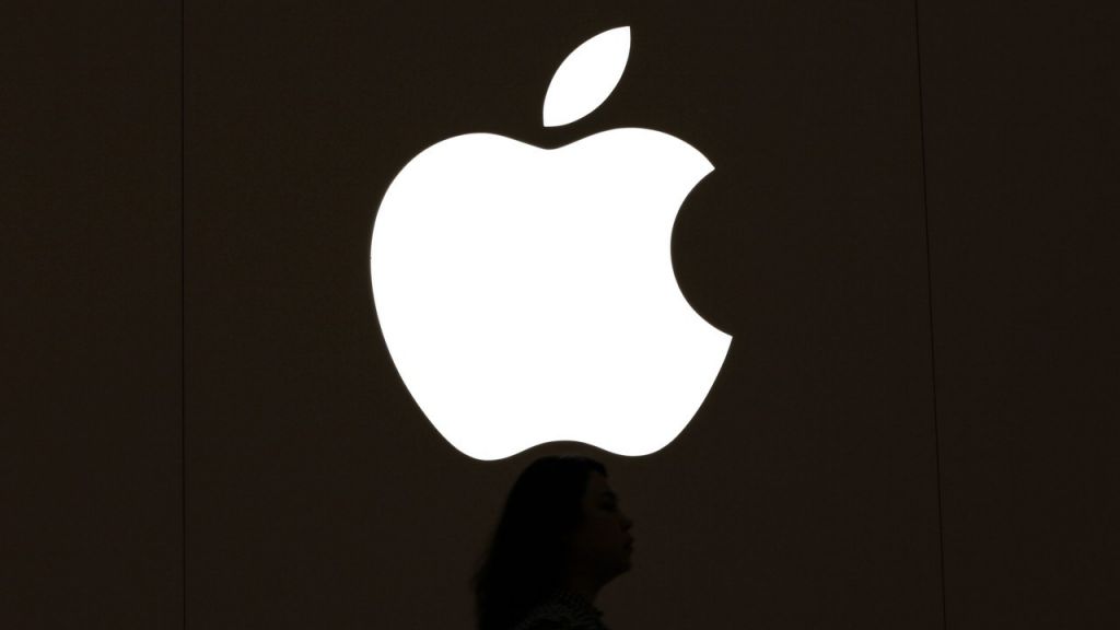 A woman walks past an Apple logo in Taipei. Apple is expected to release its new and updated product for its annual apple event today