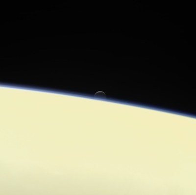 Saturn's active ocean-bearing moon Enceladus sinks behind the giant planet in a farewell portrait from NASA's Cassini spacecraft. This view of Enceladus was taken by NASA's Cassini spacecraft on Sept. 13 2017. It is among the last images Cas