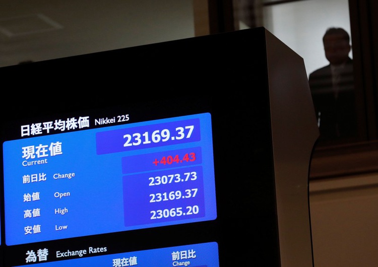 A man is seen behind an electronic board displaying the Nikkei average after the ceremony which kicks off the first day of trading in 2018