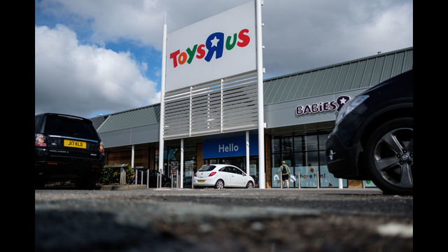 Customers walk towards a branch of the toy store Toys R Us