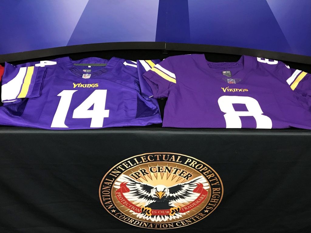 Federal officials display a counterfeit and a real jersey