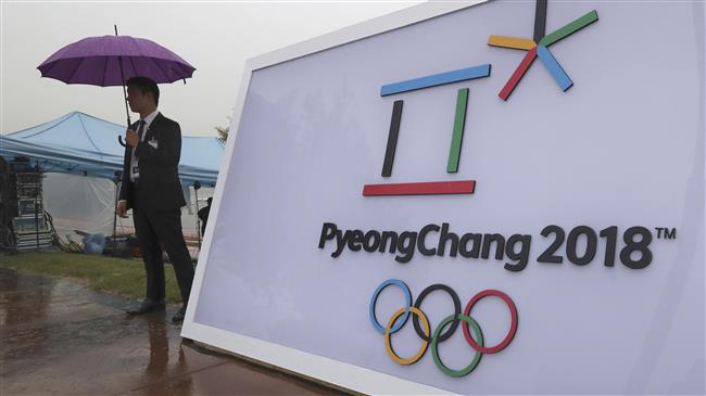 A member of security personnel stands by a logo of the 2018 Pyeong Chang Olympic Winter Games in Seoul South Korea