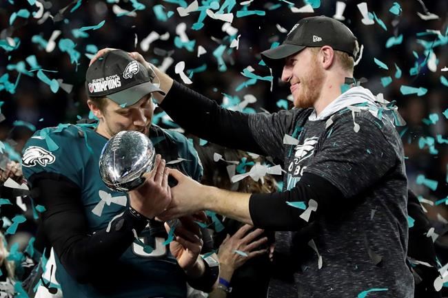 Philadelphia Eagles quarterback Carson Wentz right hands the Vincent Lombardi trophy to Nick Foles after winning the NFL Super Bowl 52 football game against the New England Patriots in Minneapolis. The Ea