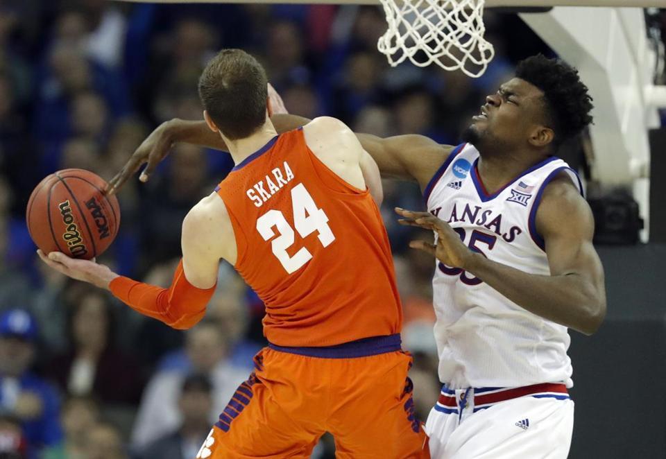 Kansas&apos Udoka Azubuike right blocks a path to the basket by Clemson's David Skara during the second half of a regional semifinal game in the NCAA men's college basketball tournament Friday