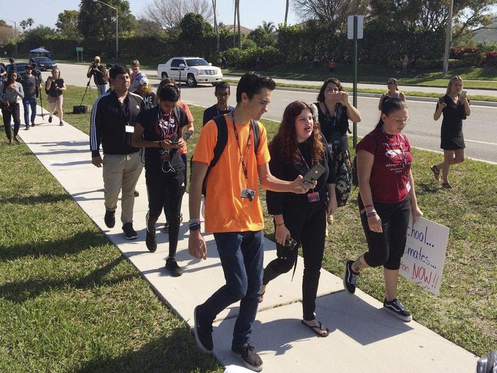 David Hogg a student activist from Marjory Stoneman Douglas High School speaks to a student as they walk out of their school