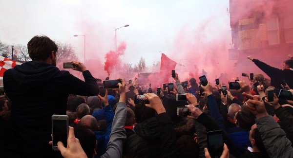 Fans let off flares as the teams arrive