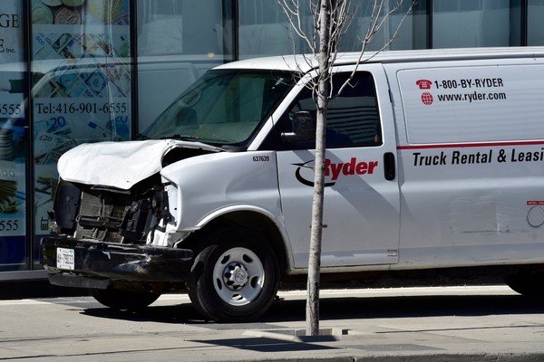 A van with a damaged front-end sits idle on a sidewalk after the driver drove down a sidewalk crashing into a number of pedestrians in Toronto Monday