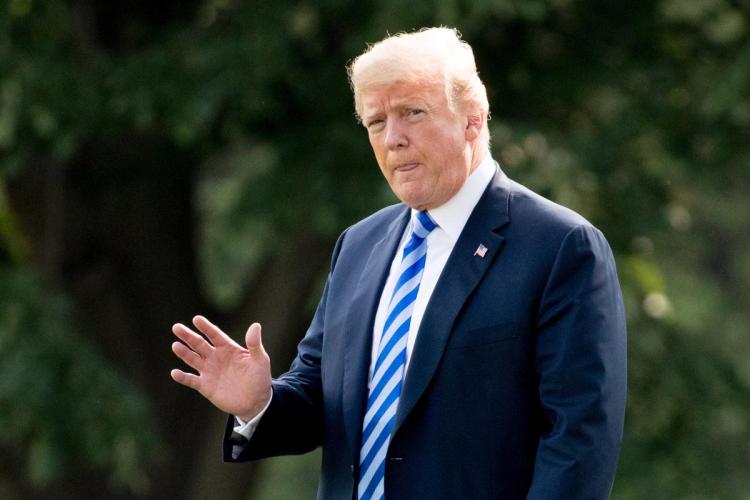 President Donald Trump waves to members of the media as he walks across the South Lawn to board Marine One at the White House in Washington Monday