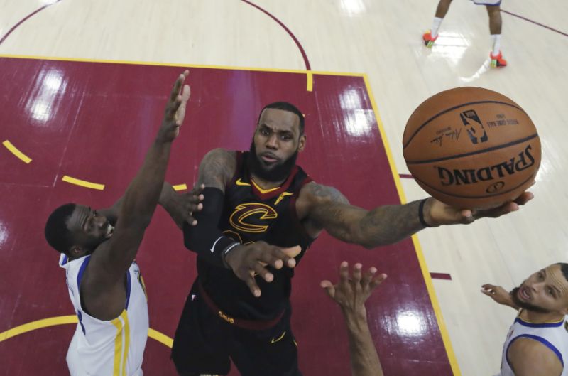 Cleveland Cavaliers&#x27 Le Bron James shoots against Golden State Warriors&#x27 Draymond Green during the first half of Game 3 of basketball's NBA Finals Wednesday